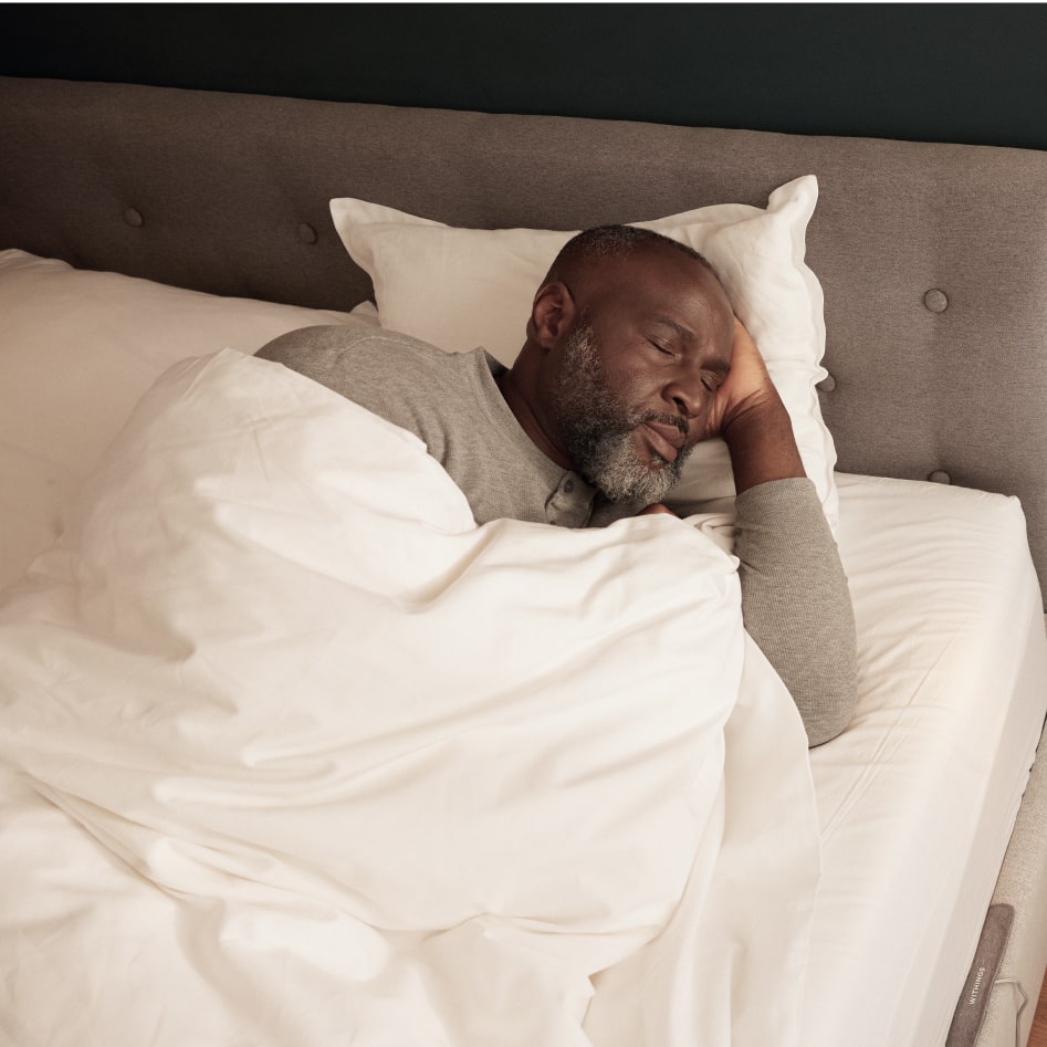 Man sleeping in their bed with Sleep Rx under mattress