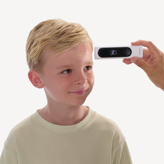 BeamO — Beam-O — Erwachsene Hand hält das Gerät, um die Stirntemperatur eines lächelnden blonden Kindes zu messen, weißer Hintergrund — Stirnscan, Kind, Erwachsene Hand, Nahaufnahme