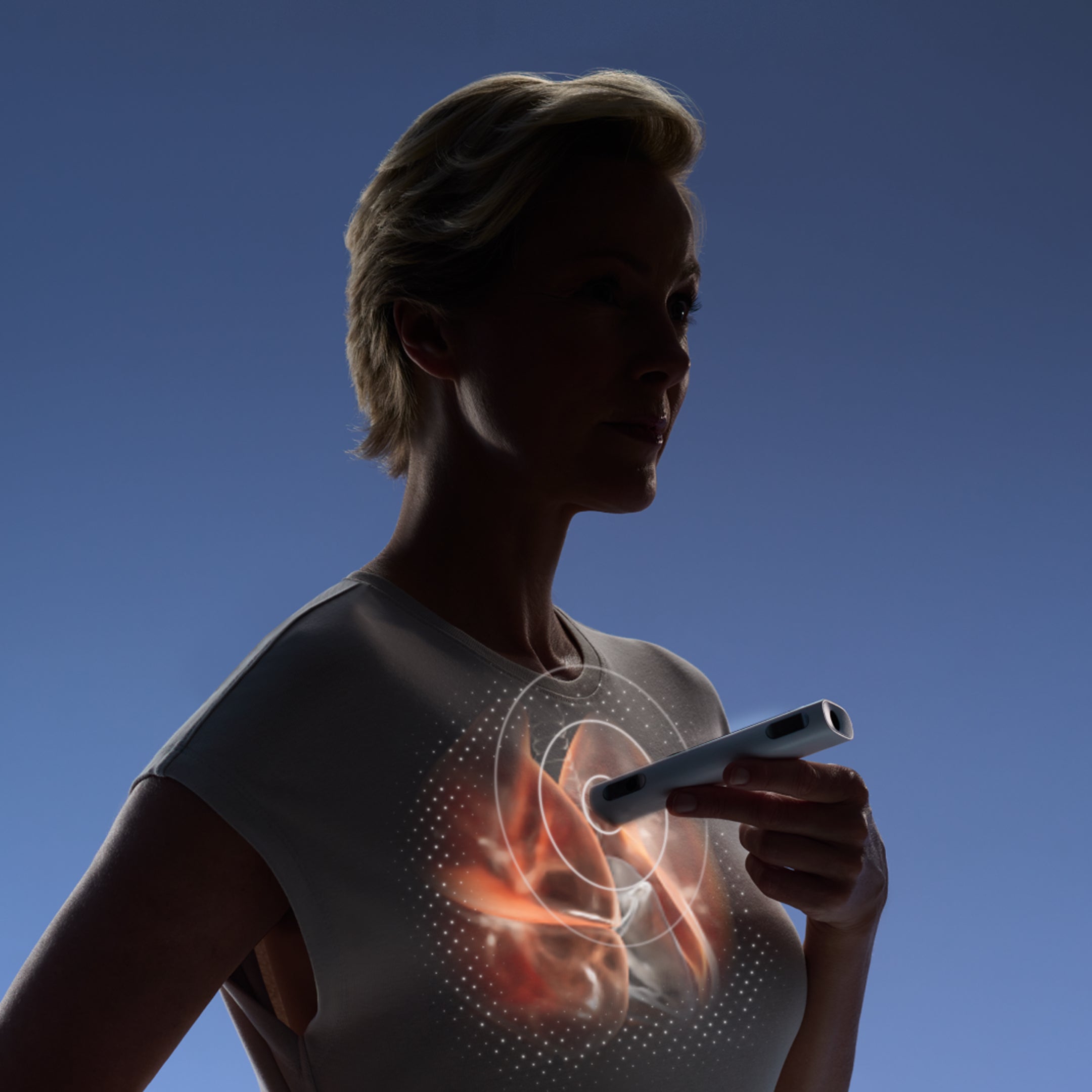 Withings BeamO — Beam-O — Frau hält Gerät zur Brust mit leuchtendem anatomischen Herz-Overlay, dramatische blaue Hintergrundbeleuchtung — halten, Brustscanner, anatomisches Overlay