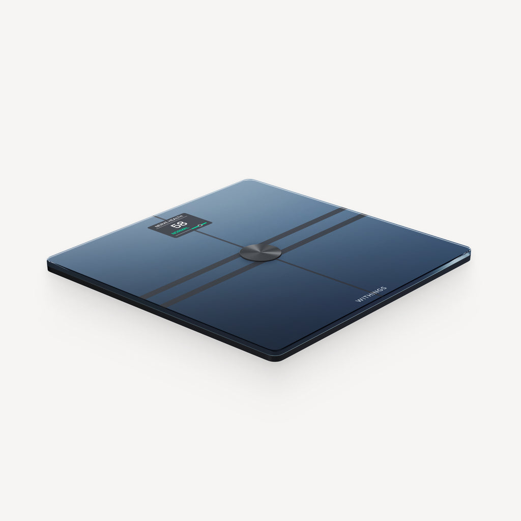 Withings Body Comp — Black — Three-quarter top-down view on white background, black glass surface with green LED display lit — three-quarter, neutral background, black glass, lit display