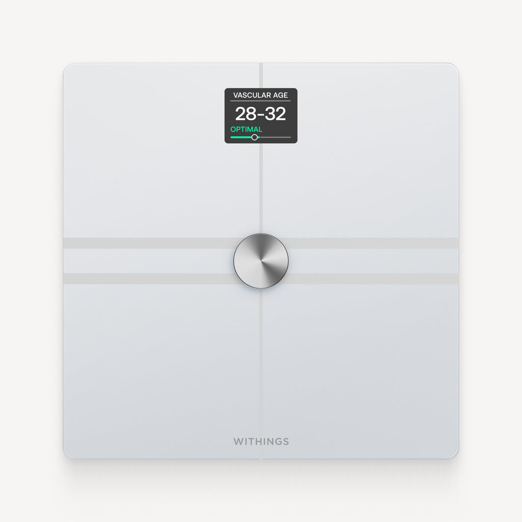 Withings Body Comp — White — Top-down view on neutral background, screen displaying vascular age 28-32 optimal — white, top-down, lit screen, plain background