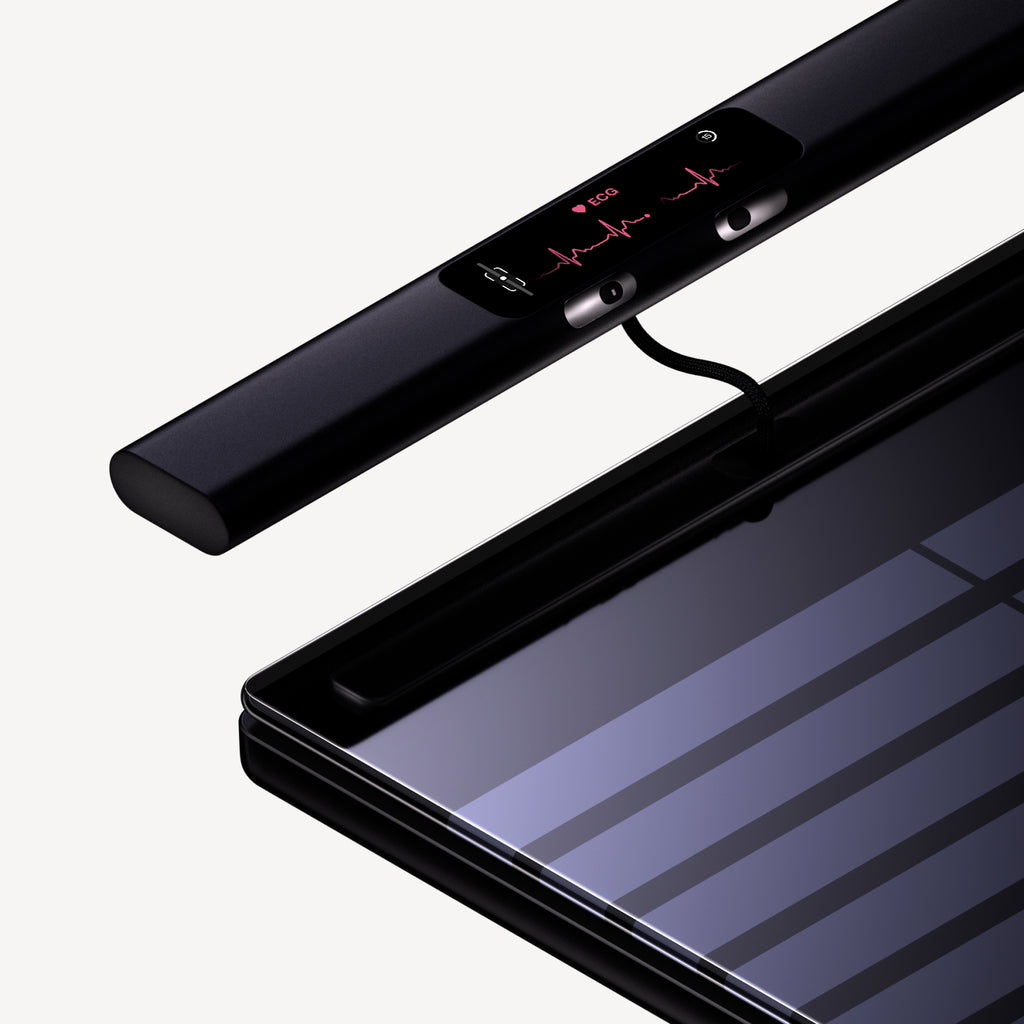 BodyScan 2 — Black — Three-quarter exploded view with detached sensor bar displaying ECG readout on neutral background — exploded view, black, ECG sensor, close-up