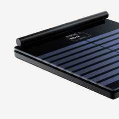 Withings Body Segment — Noir — Vue trois quarts en gros plan, surface noire rayée avec écran intégré affichant une lecture de 80,9 % de masse musculaire — gros plan, angle trois quarts, fond uni