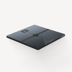 Body Smart — Black — Three-quarter perspective view on white background, glossy black glass surface with LED display, muscle mass and Withings logo — three-quarter, glossy black