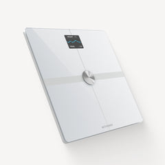 Body Smart — Wit — Driekwart verhoogde hoek op effen witte achtergrond, verlicht OLED-scherm met gewicht en trend in kg — wit, driekwart, neutrale achtergrond, verlicht scherm